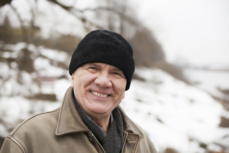 Portrait of   smiling old man in   winter afternoon