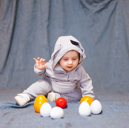 Baby   in rabbit costume and with Easter eggs.