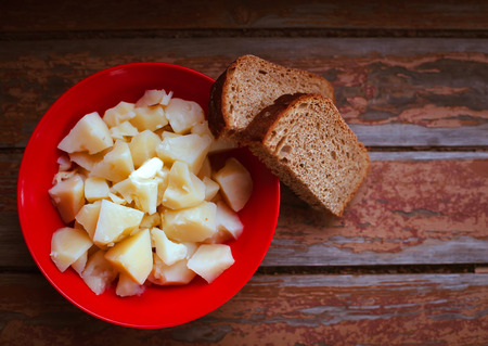 Still life with potatoes and bread on   wooden old table.