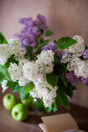 Beautiful bouquet of lilac in   glass vase on   light background.の写真素材