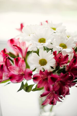 Beautiful chrysanthemum and Alstroemeria flowers in  transparent vaseの写真素材