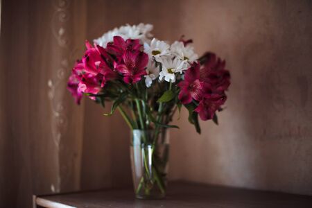 Beautiful chrysanthemum and Alstroemeria flowers in  transparent vaseの写真素材