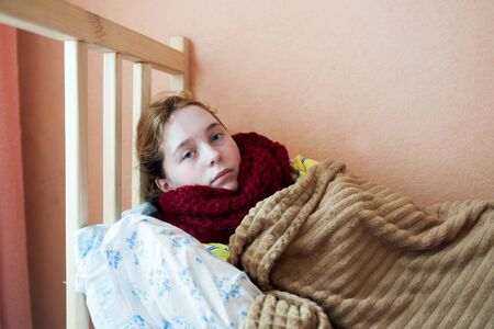 teenage sick girl   lying in bed.の写真素材