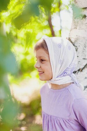 Girl   in headscarf  near   birch in   summer.の写真素材