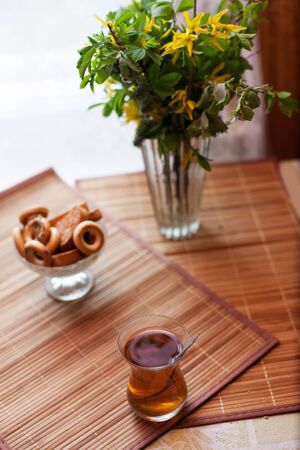 Turkish glass with black tea on   table with breadcrumbs.の写真素材