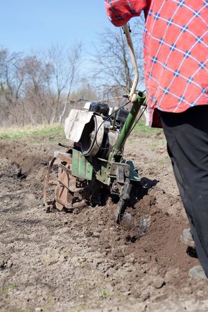 man plowing   land with   cultivatorの写真素材