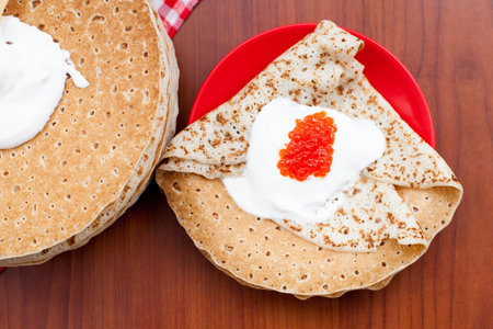 Shrovetide, pancakes with sour cream on wooden background. The view from the top. The concept of cooking, Mardi Grasの写真素材