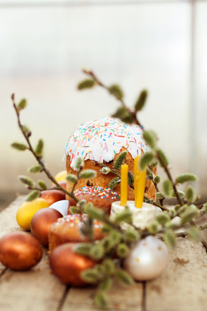 Easter cakes with colored painted eggs on wooden background