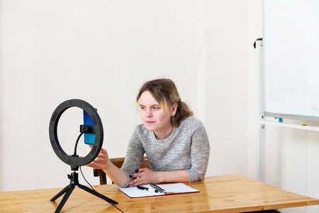 15-year-old female blogger leads live broadcast and lights herself with ring lamp in light room