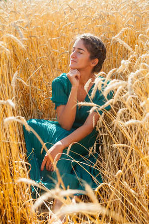 Beautiful model girl in green long dress in natureの写真素材