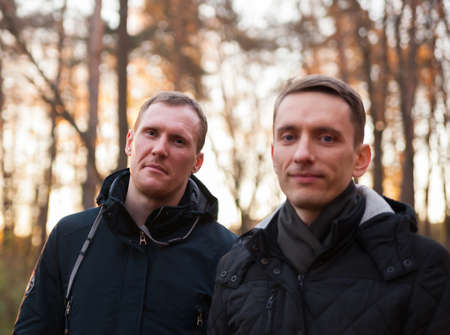 Portrait of two men on street on autumn day in park.の写真素材