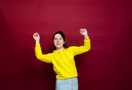 Portrait of beautiful teenage girl on red backgroundの写真素材