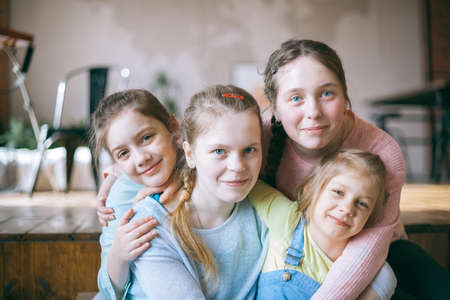 Smiling funny teenage girls sitting next to each other on couch.の写真素材