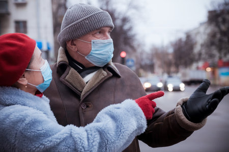 Elderly couple on street in winter in medical masksの写真素材