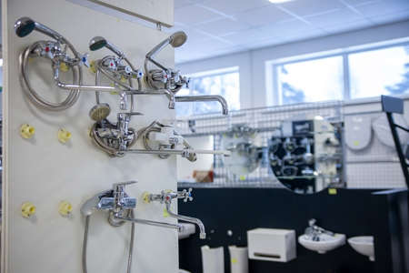 Water taps of different types and shapes on the counter in the store. Retail trade in sanitary ware. Foreground. Selective focusの写真素材