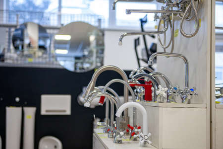 Water taps of different types and shapes on the counter in the store. Retail trade in sanitary ware....