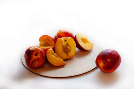 Still life of ripe nectarines,full and cut in half on light window background.の写真素材