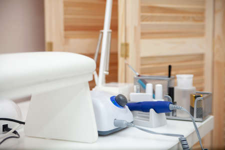 Nail salon table with manicure tools and nail polish bottles on green background. beauty treatment conceptの写真素材