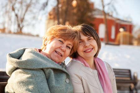 Contemplative casual senior women sitting on bench in spring parkの写真素材