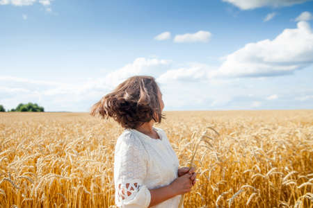 Lonely beauty mature woman, walks on the wheat field, horizontal photoの写真素材