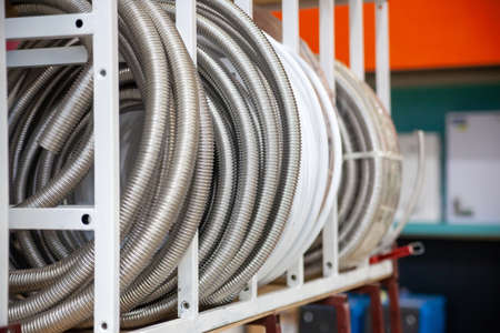 Pvc pipes wound in coils on shelves of store's warehouse.の写真素材