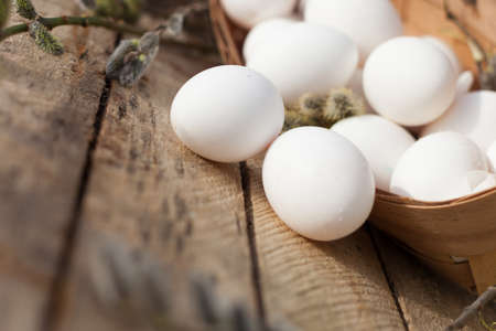 Still life with fresh white chicken eggs on wooden background.