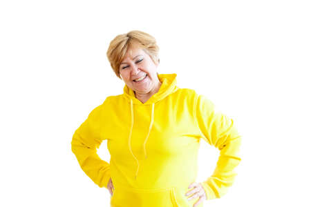 Portrait of mature 55-year-old woman in yellow hoodie.の写真素材