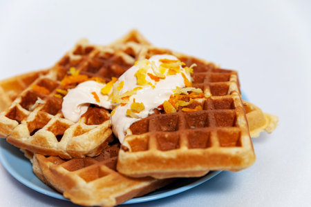 Portion of Belgian waffles with yogurt and citrus zestの写真素材