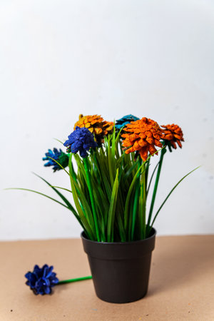 Hand-made from painted cones and a pot with artificial grass. flowers from conesの写真素材