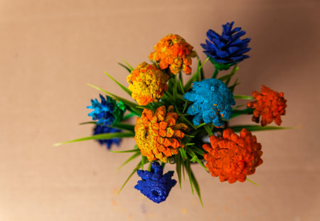 Hand-made from painted cones and a pot with artificial grass. flowers from conesの写真素材