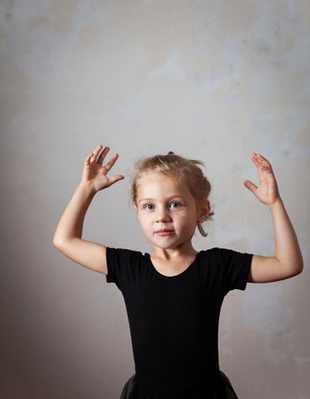 Girl dancing in ballet Studio. beautiful little blond girl standing in choreographic pose.