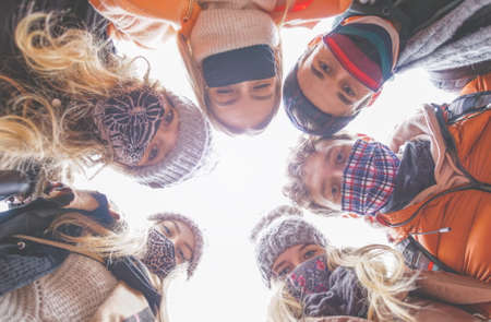 Diverse people wearing mask and taking a selfie - New normal concept with friends. Happy friends fun...