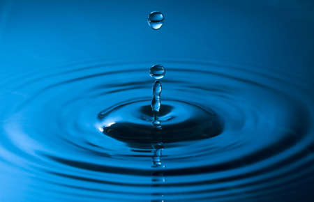 close up of a drop of water in blue colorsの写真素材