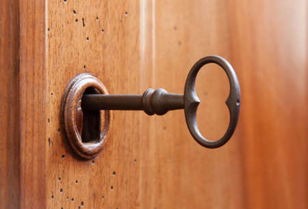 old metal key in a lock woodenの写真素材