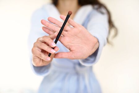 The girl in the bathroom, in a blue robe makes makeup, cosmetics, brushes, make up tool, beauty bloggerの写真素材