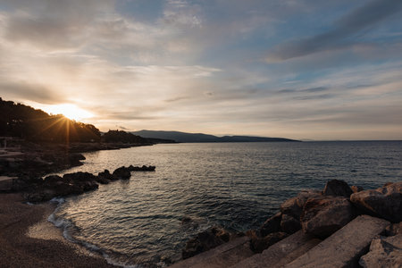 Sunset on the seashore in Croatia, relaxation on a sandy pebble beach, calm seaの写真素材