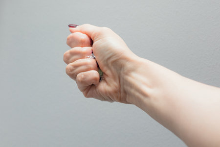 Girl's hand with dark manicure holds beauty sponge, beauty blender on white background