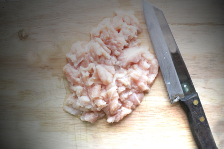 Cutted chicken fillet with knife on a chopping boardの写真素材