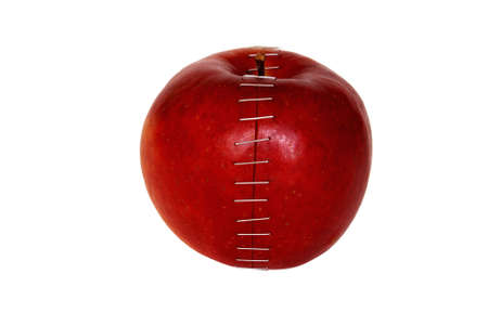 halfs of apple is connecting the staples isolated on white backgroundの写真素材