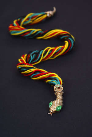 snake made from colourful woolen threads on black backgroundの写真素材