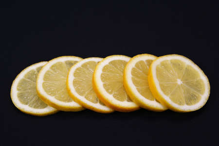 six slices of lemon on black backgroundの写真素材