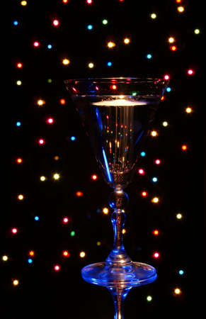 blue glass with champagne on background colorful lampの写真素材