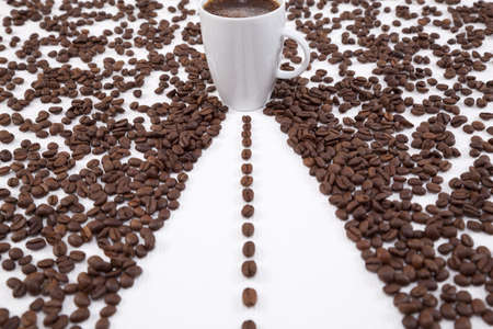 cup with coffee and spilled grains of coffeeの写真素材