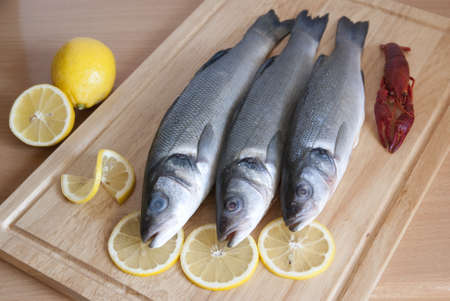 fresh fish and  lemon slices on plank