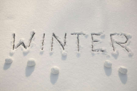 inscription of big printed letters on white snow の写真素材