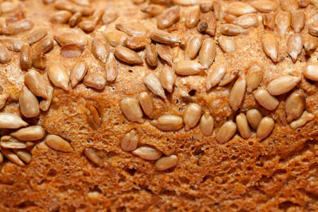 whole brown bread with sunflower seed as backgroundの写真素材