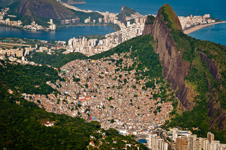 Aerial view of Favela da Rocinha, biggest slum in Brazil on the Mountain in Rio de Janeiro, and skyline of the city behindの写真素材