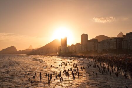 Very crowded Copacabana beach by sunset with hotel and residential buildings and mountains in the horizon. Rio de Janeiro, Brazilの写真素材