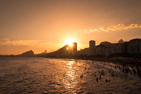 Very crowded Copacabana beach by sunset with hotel and residential buildings and mountains in the horizon. Rio de Janeiro, Brazilの写真素材