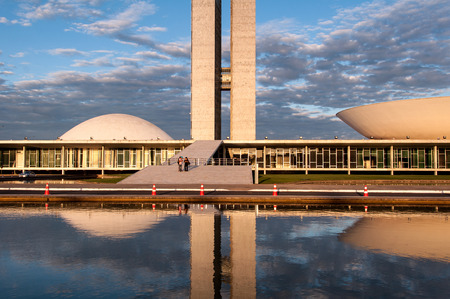Brasilia, Brazil - June 3, 2015: Brazilian National Congress reflected on water by sunset. The building was designed by Oscar Niemeyer in the modern Brazilian style.のeditorial素材